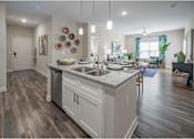 Thumbnail 33 of 74 - A kitchen with a white counter top and wooden cabinets at Waterleaf at Neely Ferry Apartments, Simpsonville