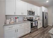 Thumbnail 34 of 74 - A kitchen with white cabinets and a granite countertop at Waterleaf at Neely Ferry Apartments, Simpsonville, SC