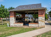 Thumbnail 11 of 30 - a brick and stone pavilion with a table and chairs under it