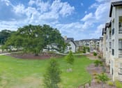 Thumbnail 28 of 50 - an aerial view of an apartment complex with a green lawn and trees at Legacy at Cibolo, Texas