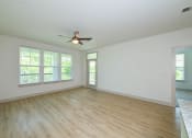 Thumbnail 46 of 50 - an empty living room with a ceiling fan and windows at Legacy at Cibolo, Boerne