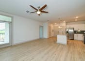 Thumbnail 48 of 50 - an empty living room with a ceiling fan and a kitchen at Legacy at Cibolo, Texas
