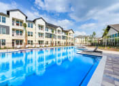Thumbnail 36 of 50 - a large swimming pool in front of an apartment building at Legacy at Cibolo, Boerne, TX, 78006