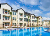 Thumbnail 25 of 50 - a swimming pool is in front of an apartment building at Legacy at Cibolo, Boerne, TX, 78006