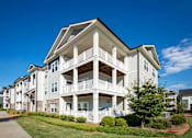 Thumbnail 50 of 74 - A white two-story apartment building with a balcony on the second floor at Waterleaf at Neely Ferry Apartments, South Carolina