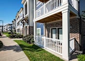 Thumbnail 51 of 74 - A row of townhouses with white railings and a sidewalk in front at Waterleaf at Neely Ferry Apartments, South Carolina 29680
