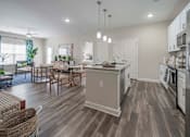 Thumbnail 46 of 74 - A modern kitchen with a dining table and chairs at Waterleaf at Neely Ferry Apartments, Simpsonville, SC