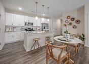 Thumbnail 69 of 74 - A kitchen with a table and chairs in the middle of the room at Waterleaf at Neely Ferry Apartments, Simpsonville, South Carolina