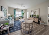 Thumbnail 64 of 74 - A well-lit, modern living room with a grey sofa, a round coffee table, and a bed in the background at Waterleaf at Neely Ferry Apartments, South Carolina