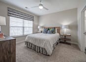 Thumbnail 63 of 74 - A bedroom with a bed, two lamps, and a ceiling fan at Waterleaf at Neely Ferry Apartments, Simpsonville