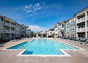 Thumbnail 59 of 74 - A large swimming pool in front of apartment buildings at Waterleaf at Neely Ferry Apartments, Simpsonville, SC 29680