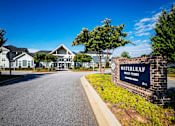 Thumbnail 40 of 74 - A sign for Waterleaf Homes stands in front of a row of houses at Waterleaf at Neely Ferry Apartments, Simpsonville, SC