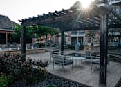Thumbnail 10 of 30 - a patio with tables and chairs and a pergola