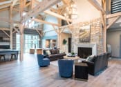 Thumbnail 9 of 32 - a large living room with couches and chairs and a fireplace at Bellary Flats Apartments, South Carolina, 29486
