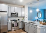 Thumbnail 15 of 32 - a kitchen with steel appliances and a counter top at Bellary Flats Apartments, South Carolina