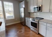 Thumbnail 31 of 32 - a kitchen with stainless steel appliances and white cabinets at Bellary Flats Apartments, Summerville , SC