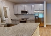 Thumbnail 32 of 32 - a kitchen with granite counter tops and stainless steel appliances at Bellary Flats Apartments, Summerville