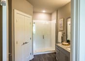 Thumbnail 8 of 20 - A bathroom with a walk in shower and a sink.