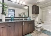 Thumbnail 11 of 18 - a bathroom with wooden cabinets and a toilet and a sink at Legacy Flats, Texas, 78254