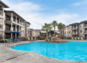 Thumbnail 3 of 18 - a large swimming pool with an apartment building in the background at Legacy Flats, San Antonio, TX