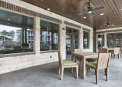 Thumbnail 6 of 18 - a covered patio with a wooden table and chairs at Legacy Flats, San Antonio