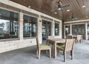 Thumbnail 16 of 18 - a patio with a wooden table and chairs at Legacy Flats, San Antonio Texas