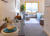 Thumbnail 13 of 18 - a living room with a dining table and a bedroom with a bed