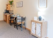 Thumbnail 15 of 18 - a dining area with a table and chairs and a cabinet with a lamp