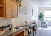 Thumbnail 14 of 18 - an open kitchen and living room with a dining room table and chairs and a window