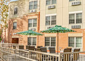 Thumbnail 2 of 18 - a patio with chairs and umbrellas in front of a building
