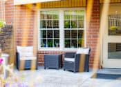 Thumbnail 7 of 18 - the porch of a home with two chairs and a door