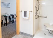 Thumbnail 16 of 18 - a bathroom with a shower and a sink and a dining table