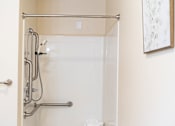 Thumbnail 17 of 18 - a small bathroom with a shower and a table in it