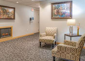Thumbnail 9 of 18 - a waiting room with two chairs and a fireplace