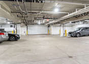 Thumbnail 8 of 18 - a parking garage with two cars parked in it