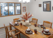 Thumbnail 5 of 35 - a dining room with a wooden table and chairs and a vase of flowers