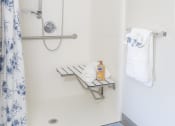 Thumbnail 9 of 35 - a small bathroom with a shower and a blue and white shower curtain