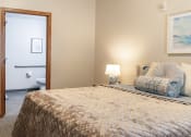 Thumbnail 11 of 35 - a bedroom with a bed and a door to a bathroom