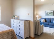 Thumbnail 14 of 35 - a bedroom with a couch and a bed and a dresser