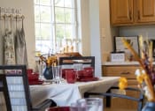 Thumbnail 18 of 35 - a dining room table with red dishes on it and a window