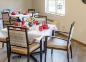 Thumbnail 19 of 35 - a dining room with tables and chairs and a window
