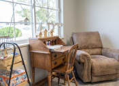 Thumbnail 20 of 35 - a living room with a chair and a desk and a window