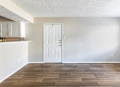 Thumbnail 6 of 28 - A room with a white door and wooden flooring.