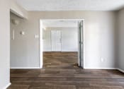 Thumbnail 12 of 28 - A room with a wooden floor and white walls.