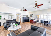 Thumbnail 4 of 28 - A living room with black leather furniture and a ceiling fan.