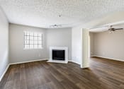 Thumbnail 19 of 28 - A living room with a fireplace and wood flooring.