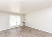 Thumbnail 14 of 19 - an empty living room with wood flooring and a window