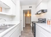 Thumbnail 16 of 19 - a renovated kitchen with white cabinets and a stainless steel sink