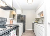 Thumbnail 15 of 19 - a white kitchen with stainless steel appliances and white cabinets