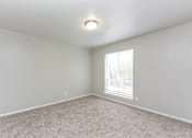 Thumbnail 17 of 19 - an empty living room with a window and carpet